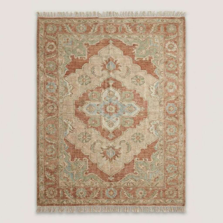 Translation missing: es.Terracotta and sage wool area rug styled in a neutral living room with an upholstered chair, showing scale and decor fit