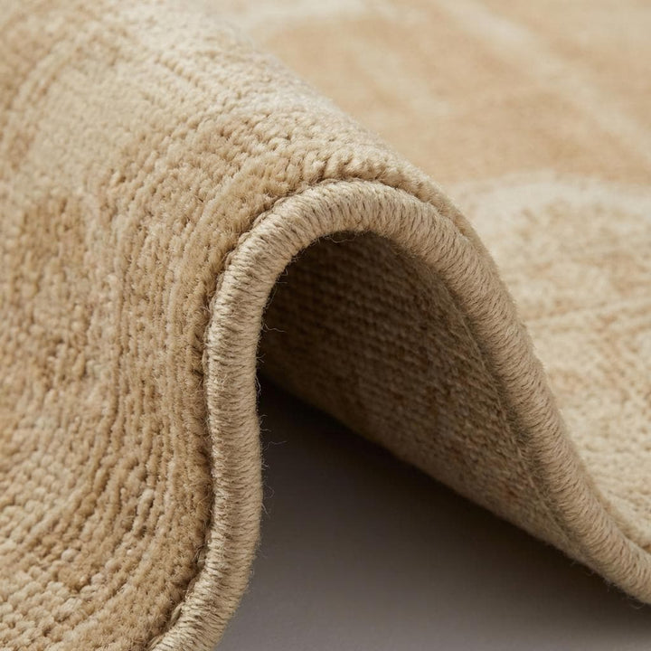 Translation missing: es.Close-up of hand-knotted wool pile showing individual knots, soft natural fibers, and subtle tonal variation in beige and cream