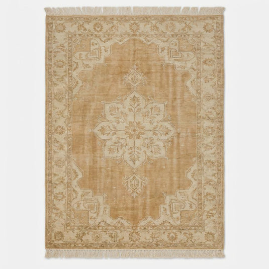 Translation missing: es.Neutral vintage wool area rug with floral border and central medallion styled beside a modern accent chair