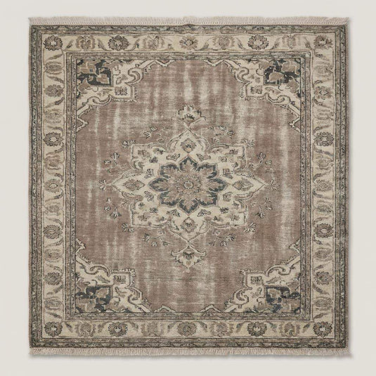 Translation missing: en.Muted Persian style area rug anchored in a bright living room with wood floors