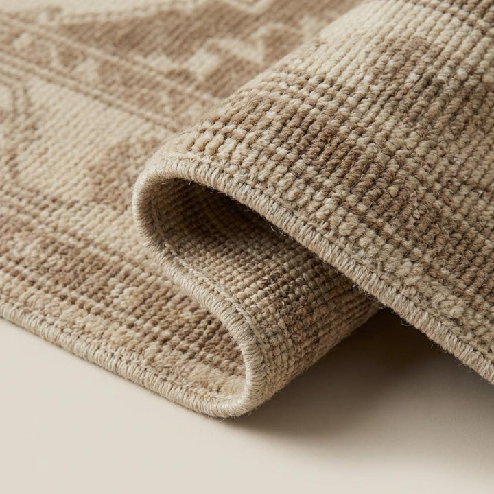 Translation missing: en.Close-up of hand knotted wool pile showing natural fiber texture, individual knot structure, and soft muted antique dye tones