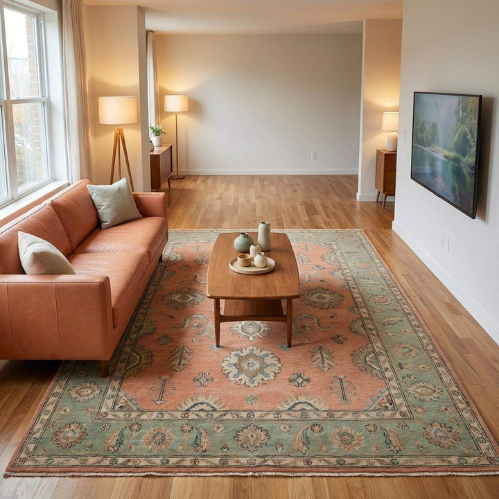 Translation missing: en.Hand knotted wool area rug displaying peach, sage green, dusty blue, and ivory color tones in natural lighting