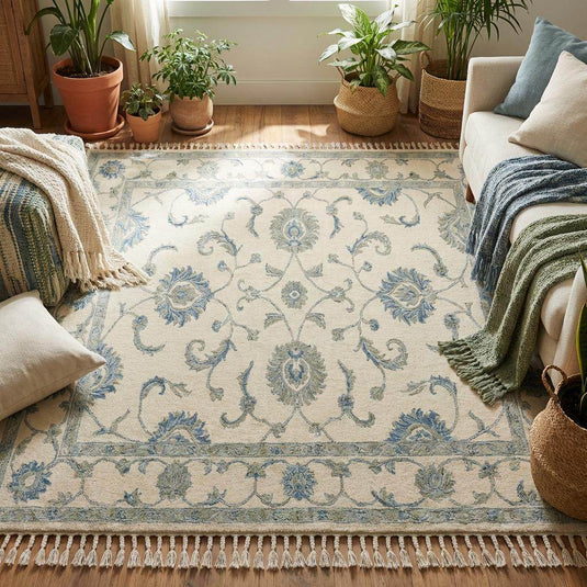 Translation missing: es.Hand knotted wool area rug with delicate vine motifs and muted blue accents on cream background