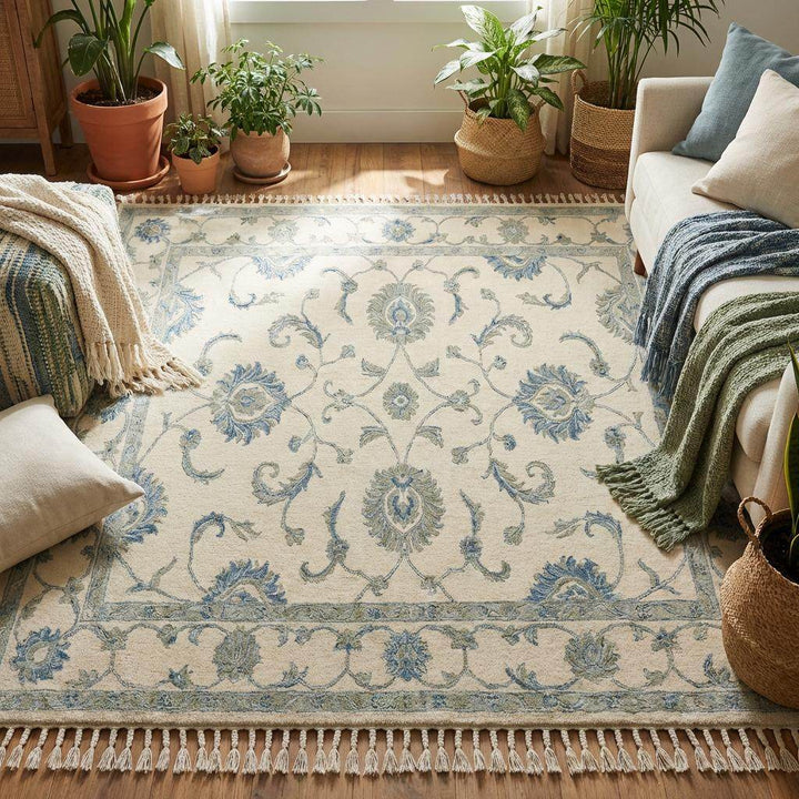 Translation missing: es.Hand knotted wool area rug with delicate vine motifs and muted blue accents on cream background