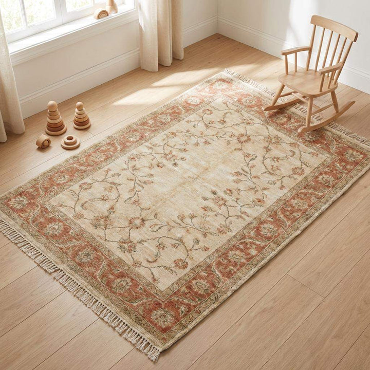 Translation missing: es.Ivory and peach hand knotted wool rug with classic border design and fringe detail