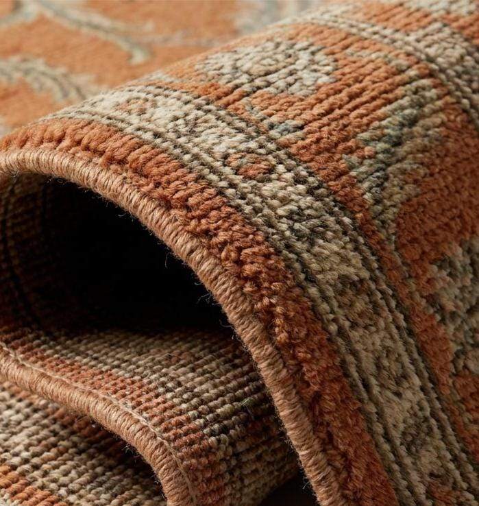 Translation missing: es.Close-up texture of a hand-knotted wool rug showing individual knot structure, low pile height, and intricate cream and olive green floral weaving