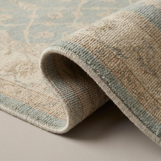 Translation missing: es.Close-up of hand knotted wool rug showing dense individual knot structure, soft wool fibers, and subtle tonal variation in blue and beige field