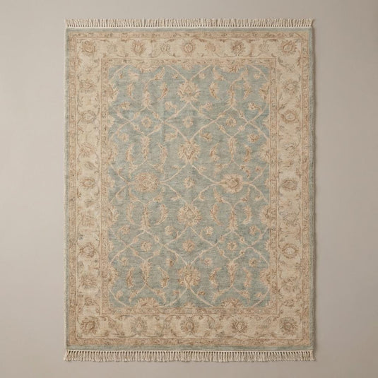 Translation missing: es.Vintage style blue and beige Oushak area rug with floral motifs placed on dark hardwood floor