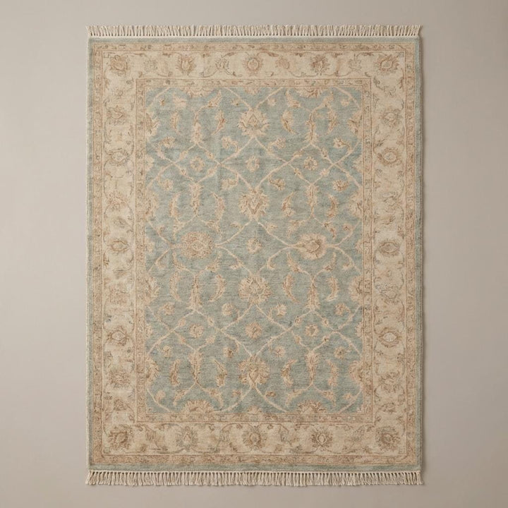 Translation missing: en.Vintage style blue and beige Oushak area rug with floral motifs placed on dark hardwood floor