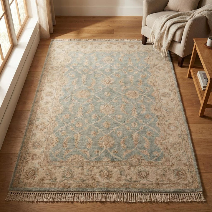 Translation missing: en.Traditional floral wool rug with fringe detail styled beside wooden armchair and pottery shelf