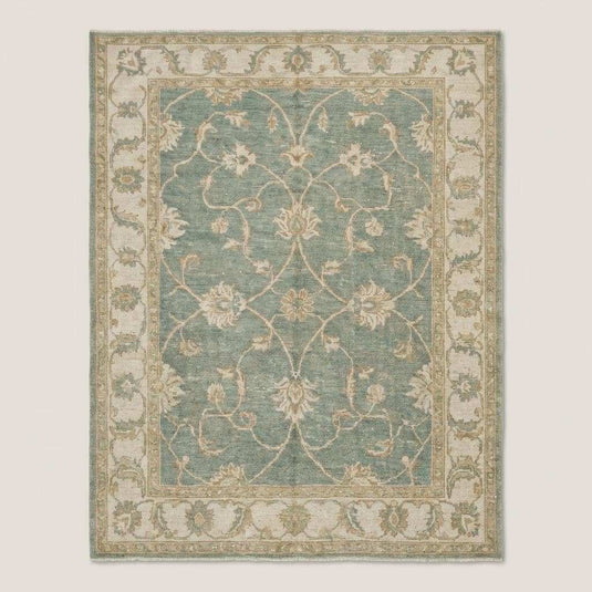 Translation missing: en.Traditional Oushak area rug with muted green and ivory tones in natural light