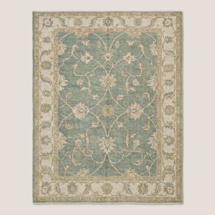 Translation missing: en.Traditional Oushak area rug with muted green and ivory tones in natural light