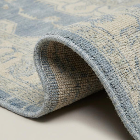 Translation missing: fr.Close-up of dense hand knotted wool pile showing individual knots, soft vintage wash, and natural fiber texture
