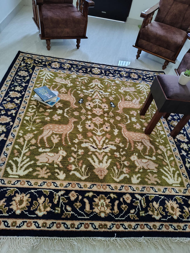 Translation missing: es.Hand knotted wool rug with Persian animal motifs, green field and navy floral border