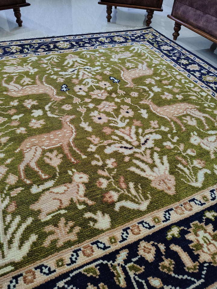 Translation missing: es.Hand knotted wool rug with green Persian animal motifs and navy floral border