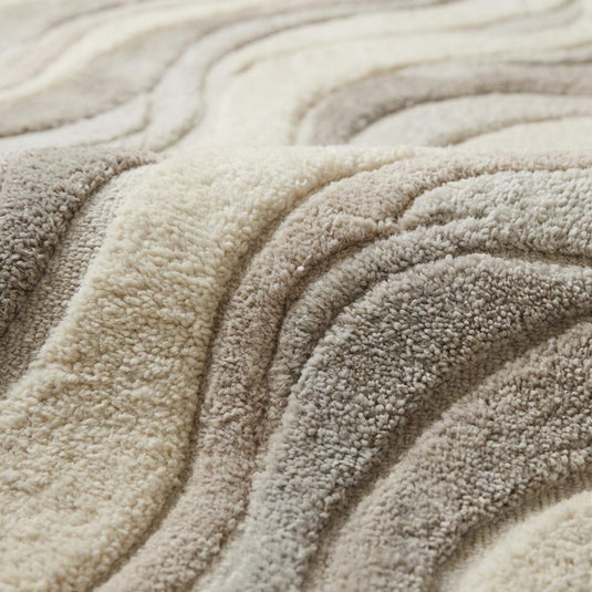 Translation missing: es.Close-up of carved high-low hand tufted wool pile showing soft dense fibers and sculpted wave texture