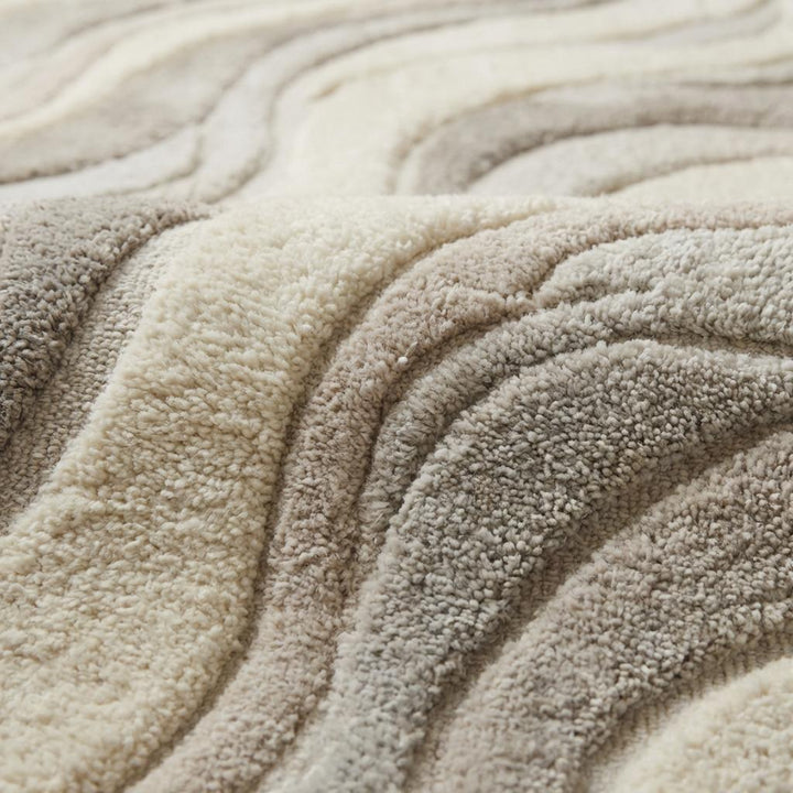 Translation missing: es.Close-up of carved high-low hand tufted wool pile showing soft dense fibers and sculpted wave texture