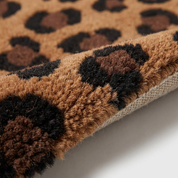 Translation missing: en.Close up of thick hand tufted wool pile showing dense cut fibers and plush leopard pattern detailing in brown and black tones