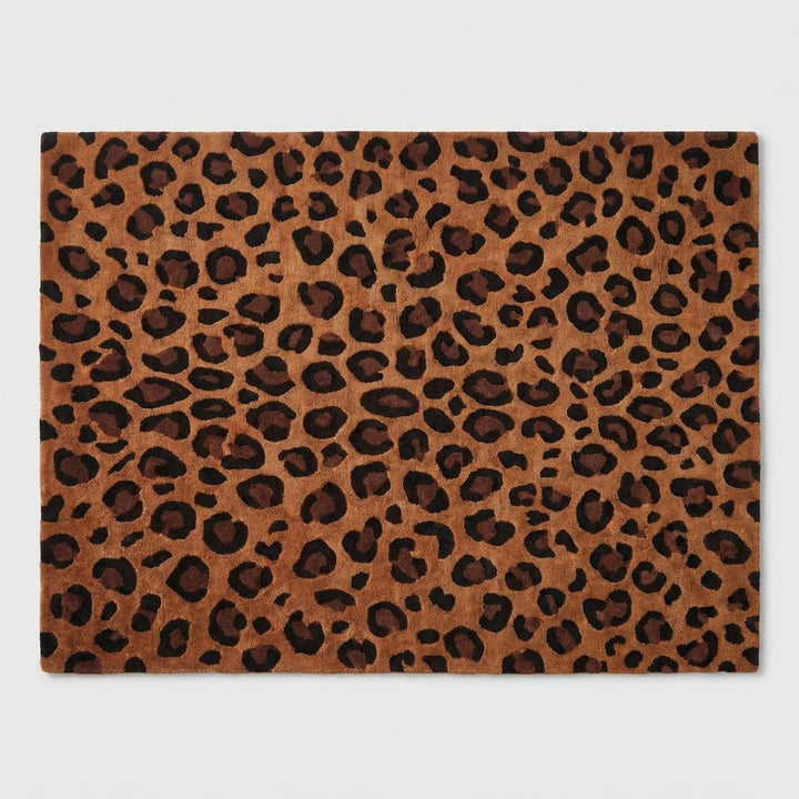 Translation missing: en.Modern 8x10 leopard print area rug styled in minimalist living room with warm neutral décor