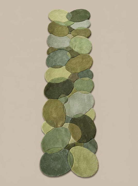 Translation missing: es.Modern organic runner rug with layered moss and sage green pebble shapes on wood floor