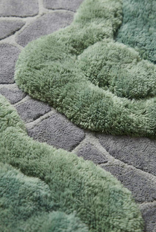 Translation missing: es.Close-up of dense wool tufted pile showing raised moss-like texture and carved stone pattern detail