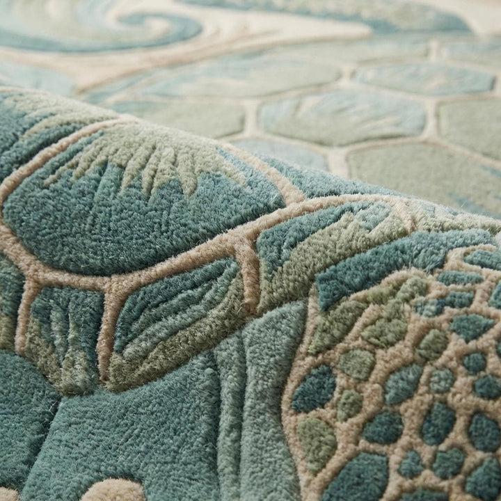 Translation missing: en.Close-up of hand tufted wool rug showing carved cut pile texture, sculpted sea turtle shell detailing, and raised wave patterns in teal and sand tones