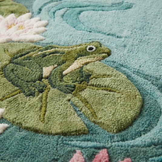 Translation missing: es.Close-up of hand tufted wool rug showing dense cut pile fibers, carved sculpted detailing around lily pads and raised botanical texture