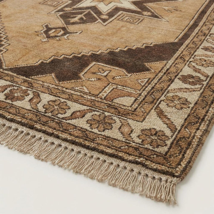 Translation missing: en.Close-up of hand knotted wool rug showing dense natural wool pile and individual knot texture with earthy beige and brown fibers
