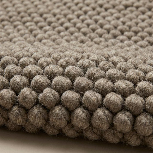 Translation missing: es.Handmade chunky knit wool rug detail showing thick loops and natural wool fibers for minimalist home decor