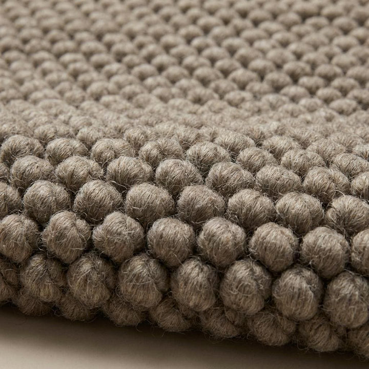 Translation missing: es.Handmade chunky knit wool rug detail showing thick loops and natural wool fibers for minimalist home decor