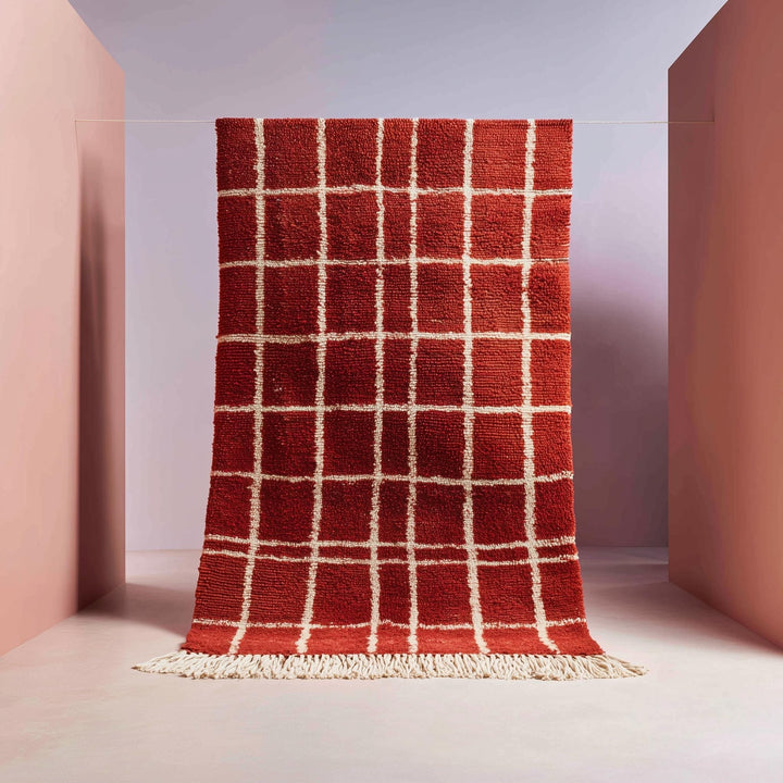 Translation missing: es.Handmade Moroccan wool rug with brick red base and white grid pattern featuring fringe ends and boho style