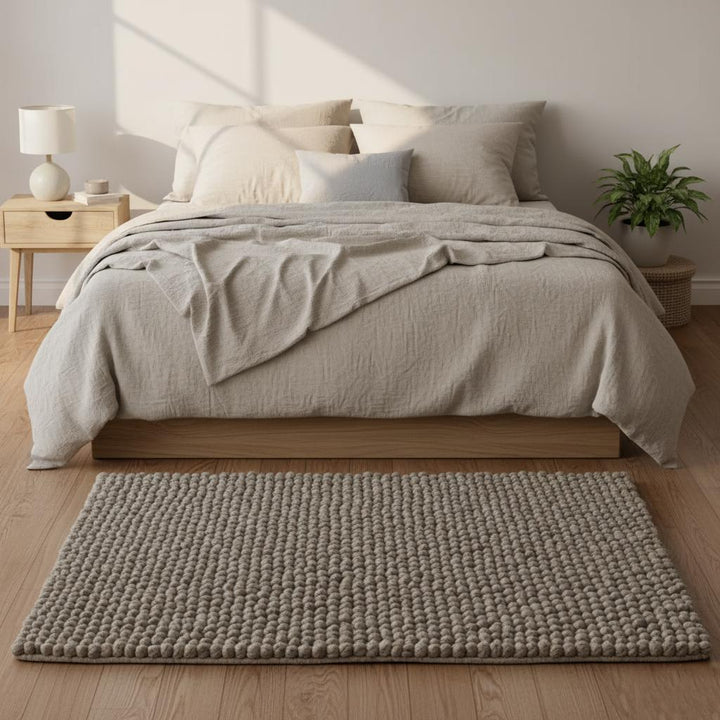 Translation missing: en.Close top view: rectangular wool felt-ball rug in stone taupe, handcrafted pom-pom texture, suitable as a gift or nursery accent rug