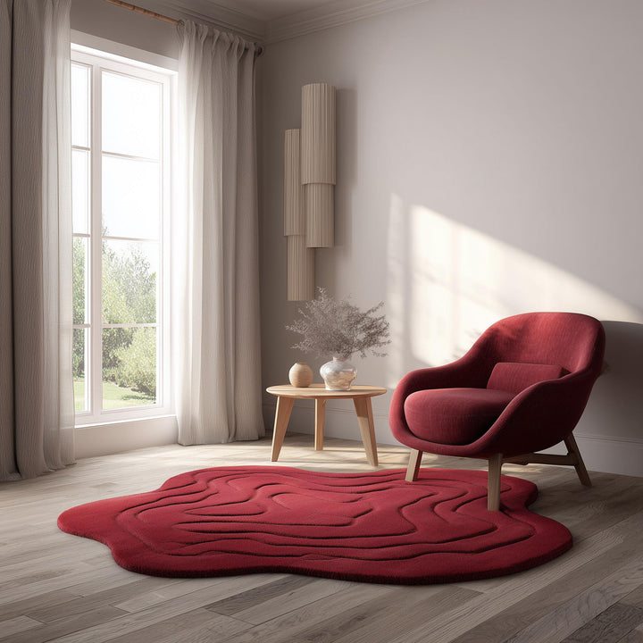 Translation missing: en.Handmade tufted red rug in modern irregular shape with 3D wave design, styled in a cozy living room with wooden floor, neutral walls, and natural light