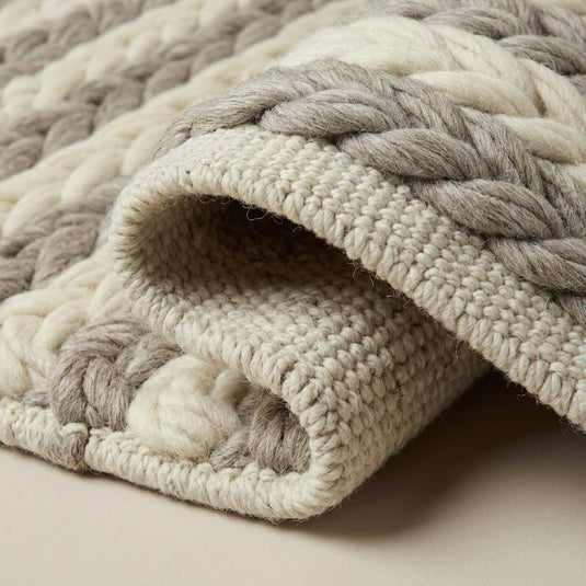 Translation missing: es.Close-up of thick handwoven wool braids on a chunky wool area rug in natural soft colors for Scandinavian home styling