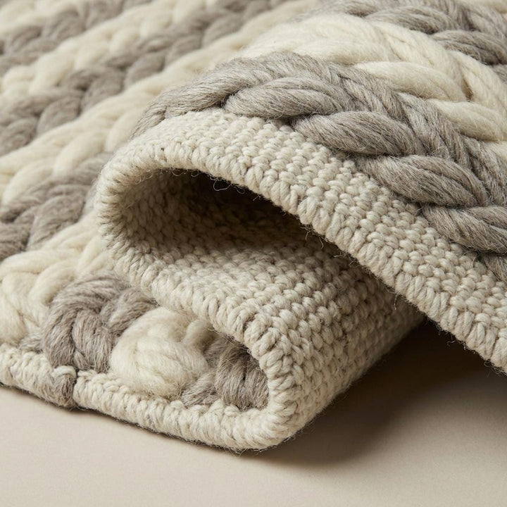 Translation missing: es.Close-up of thick handwoven wool braids on a chunky wool area rug in natural soft colors for Scandinavian home styling