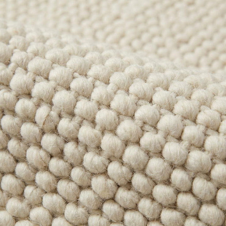 Translation missing: es.Close up of chunky knitted wool rug showing thick natural yarn and soft woven texture