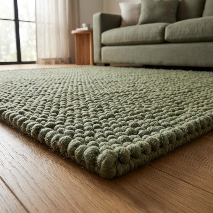 Translation missing: es.Close-up of chunky handwoven wool rug showing thick braided texture and soft sage green color