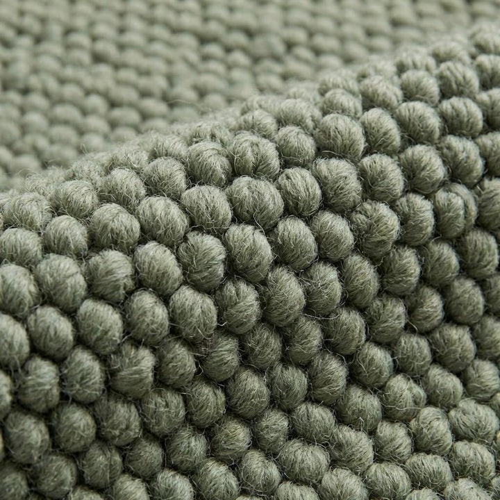 Translation missing: es.Close-up of chunky wool rug showing thick knitted wool fibers, natural handmade rug for rustic and modern homes