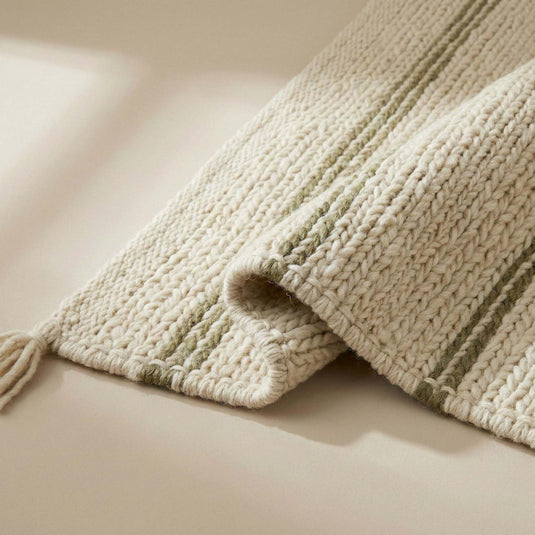 Translation missing: es.Handwoven wool area rug with chunky knit, cream base, green stripes, and tassels