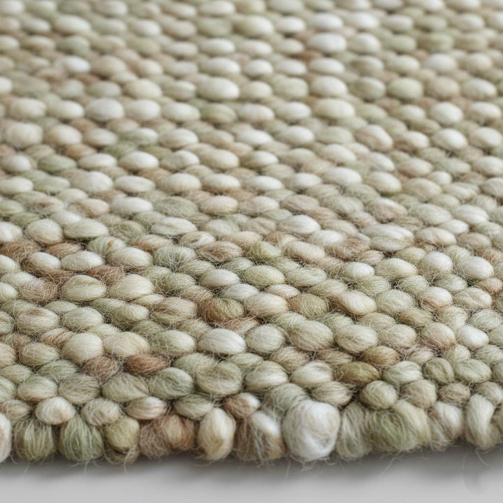 Translation missing: es.Handwoven wool pebble rug in sage green and cream with chunky textured loops for boho nursery or living room decor