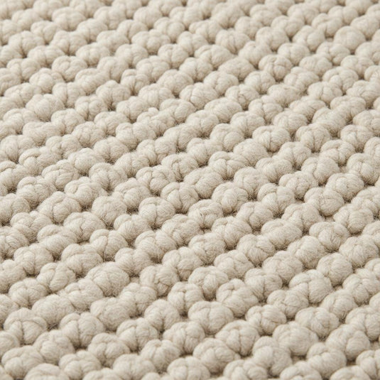 Translation missing: es.Close-up of thick loop pile wool rug showing natural fibers and cozy handmade construction