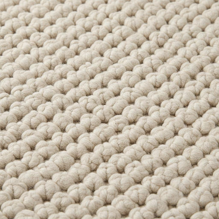 Translation missing: es.Close-up of thick loop pile wool rug showing natural fibers and cozy handmade construction