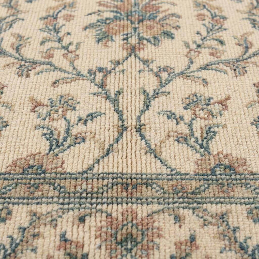 Translation missing: es.Close-up of hand knotted wool pile showing individual knot texture, dense ivory yarn, and detailed floral pattern