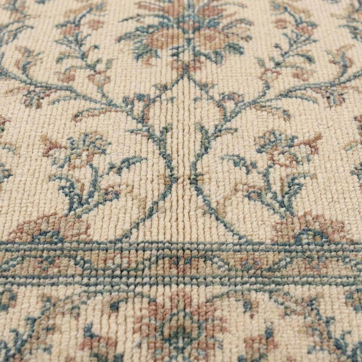 Translation missing: en.Close-up of hand knotted wool pile showing individual knot texture, dense ivory yarn, and detailed floral pattern