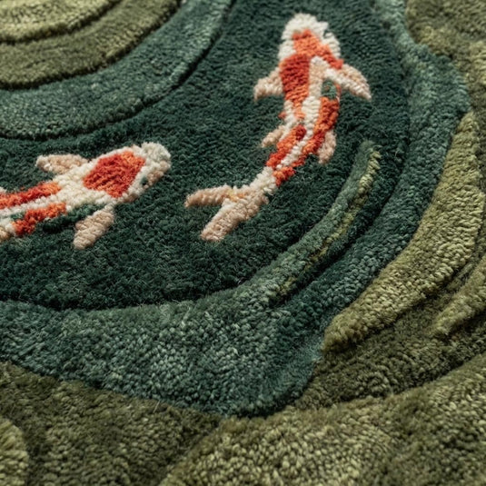 Translation missing: es.Close-up of dense wool hand-tufted pile showing carved contours, soft looped fibers, and raised koi fish detailing
