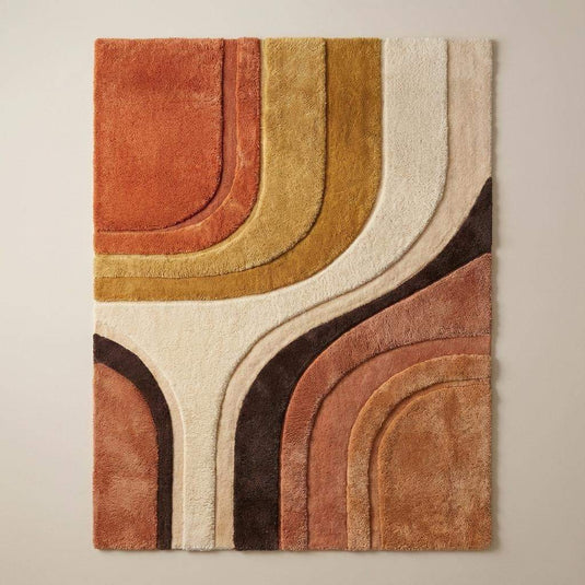 Translation missing: en.Retro modern hand tufted area rug placed in a living room with sofa and accent chair, warm tones enhancing mid century decor