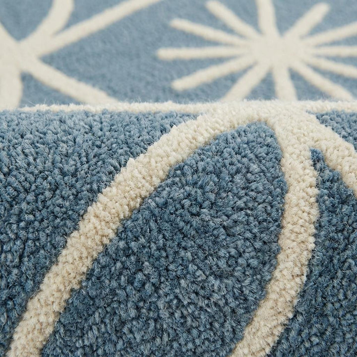 Translation missing: en.Close-up detail of plush blue and cream geometric rug showing raised tufted starburst pattern, dense fibers, and soft textured pile craftsmanship