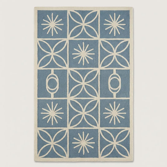 Translation missing: es.Top-down view of mid century modern blue and cream area rug with grid layout, retro starburst motifs, and clean ivory border design