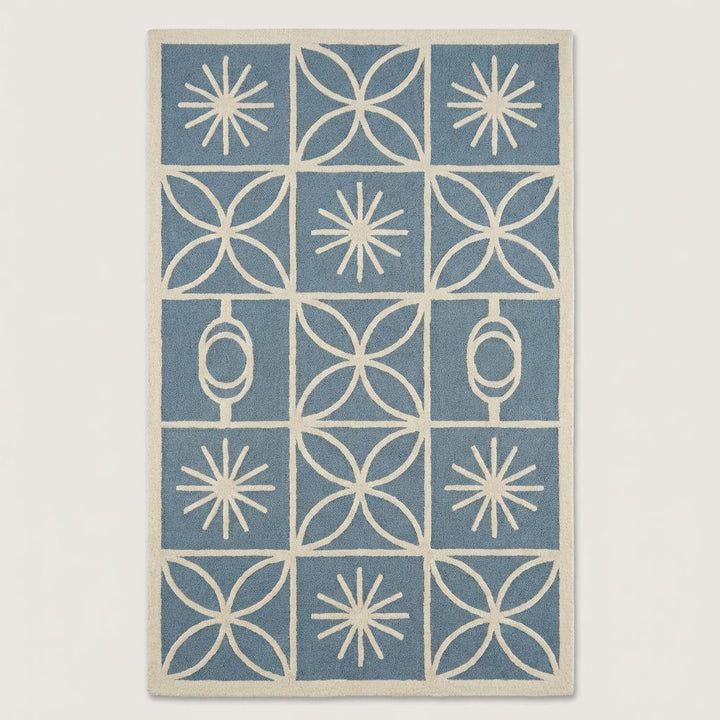 Translation missing: en.Top-down view of mid century modern blue and cream area rug with grid layout, retro starburst motifs, and clean ivory border design