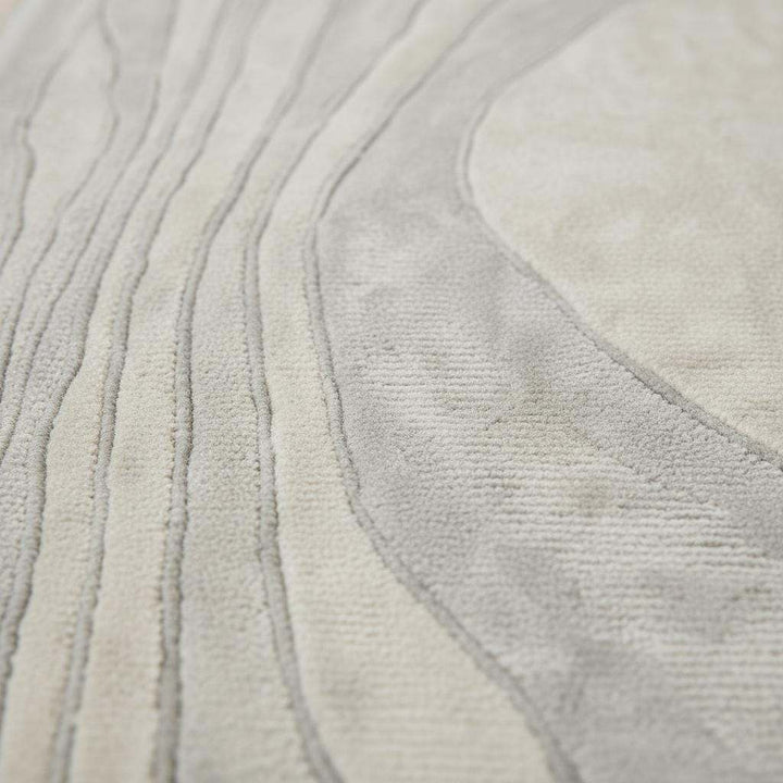 Translation missing: es.Close-up of tufted runner rug showing dense low-pile texture, soft fibers, carved wave lines, and matte neutral finish